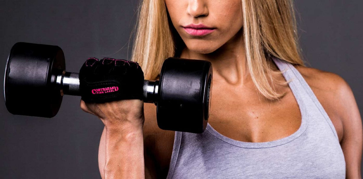 Woman lifting a dumbbell in Pink Label gloves